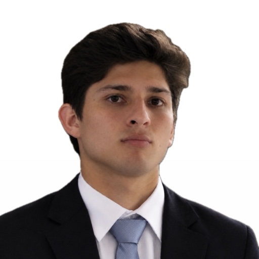 Sebastián Tapia con expresión seria, saco azul marino, camisa blanca y corbata azul claro, sobre fondo blanco.